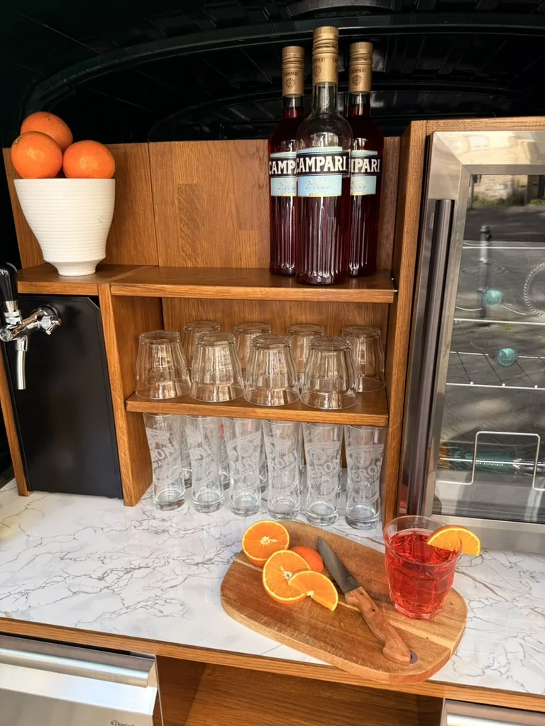 Campari, Gläser und frische Orangen in der Bar